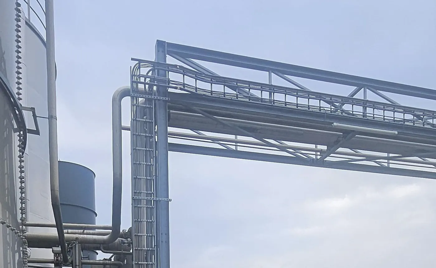 Stalen pijpbrug tussen opslagtanks op een productieterrein