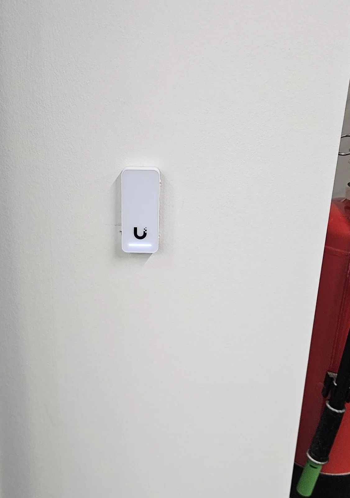 Toegangslezer met blauw lampje op een witte wand
